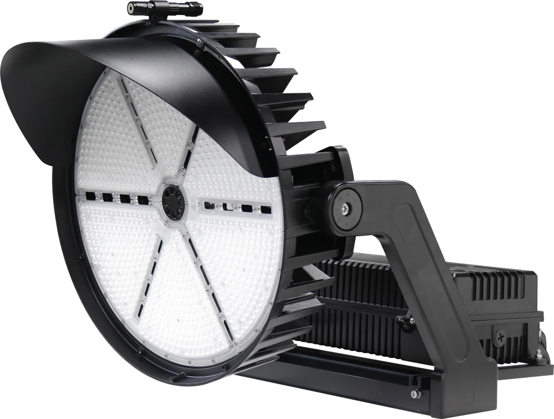 Radiator Series LSPL stadium-grade sports lighter — primary 3/4 angle view showing the round prismatic optic face, finned heat-sink housing, trunnion mount, and integrated driver compartment · alpha-cutout transparent background